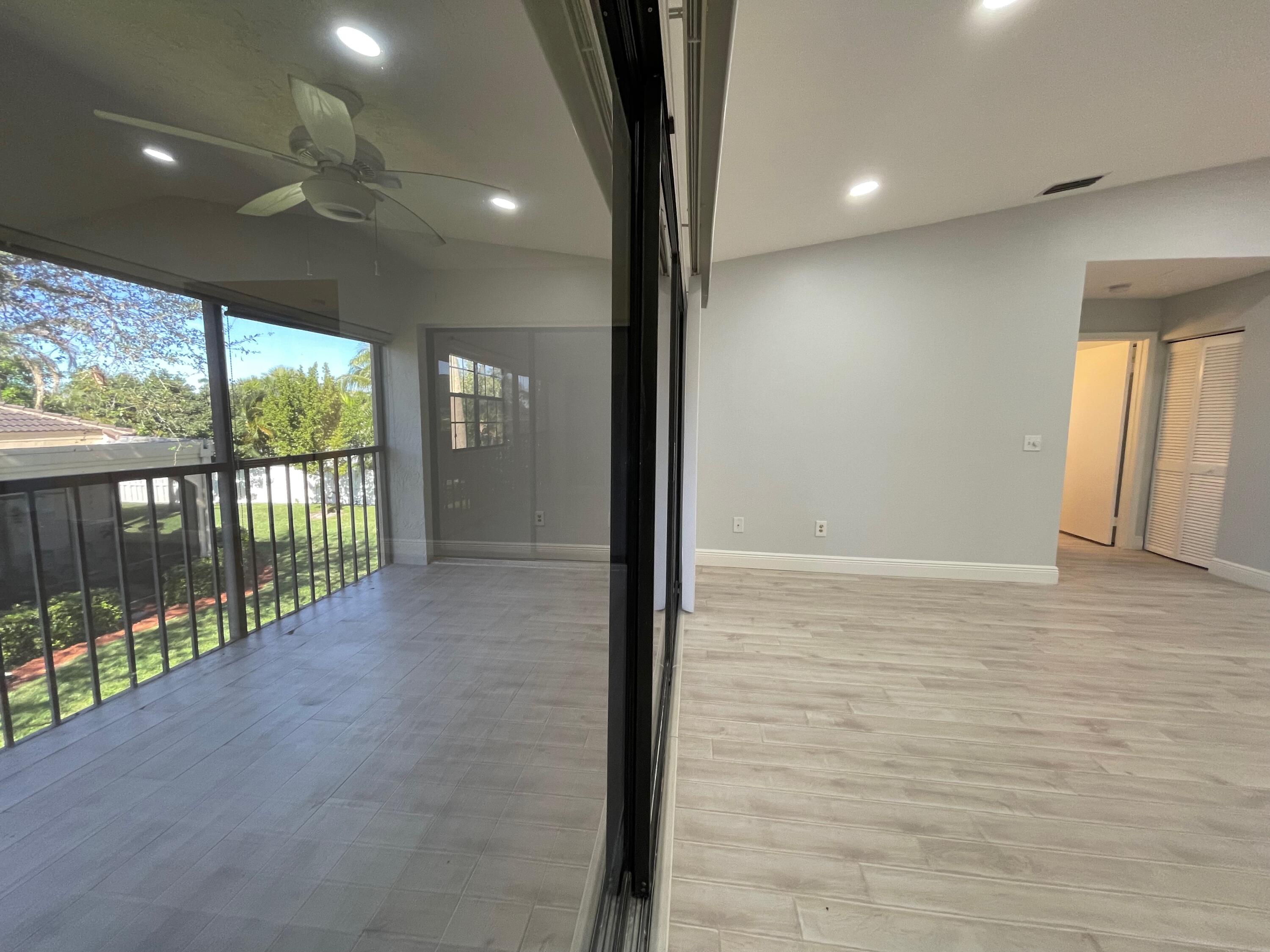 6691 Montego Bay Boulevard, Unit H Boca Raton, FL 33433 - Photo 10 of 22 a view of hallway with a floor to ceiling window and wooden floor