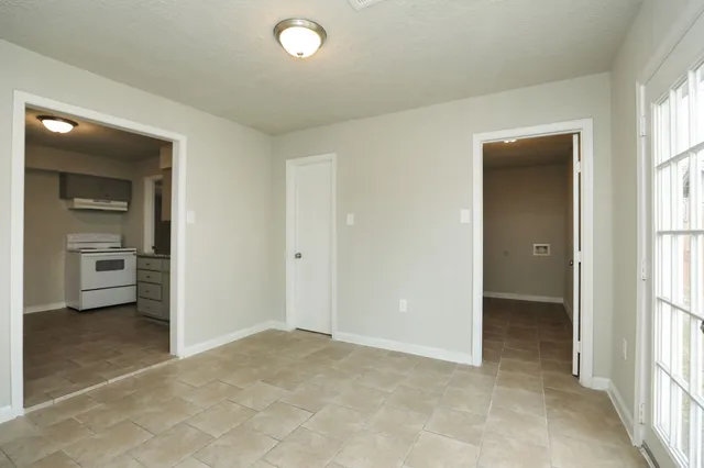 a view of a hallway with wooden floor and a bathroom
