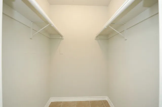 an empty room with wooden floor chandelier fan and windows
