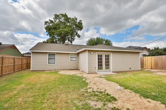 a view of a backyard with table and chairs and wooden fence
