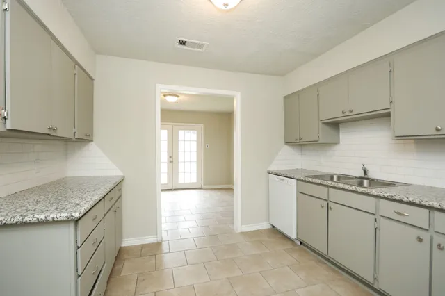 a kitchen with a stove sink and cabinets