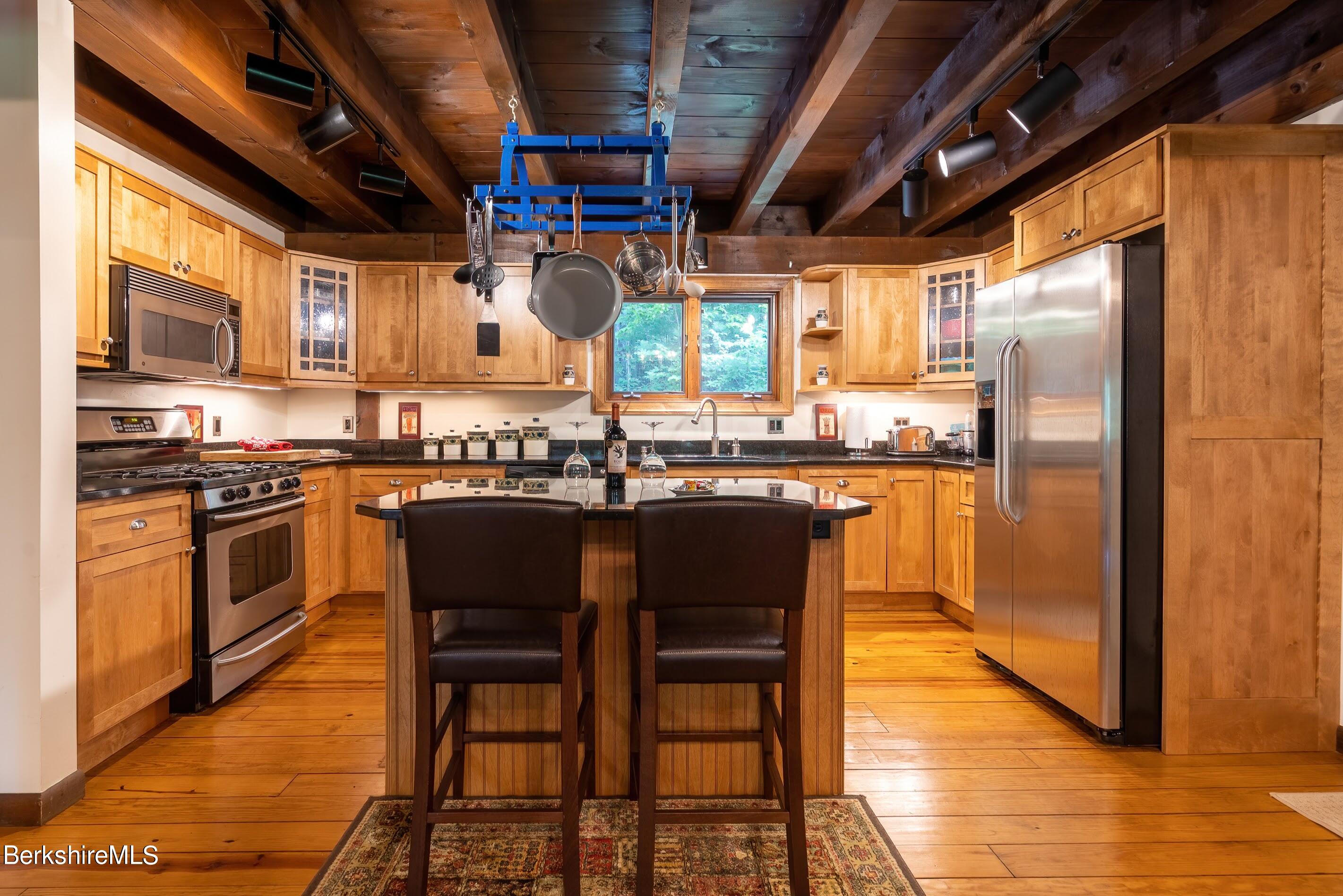 161 Capt Whitney Road Becket, MA 01223 - Photo 12 of 29 a kitchen with stainless steel appliances granite countertop a stove a sink dishwasher a refrigerator with wooden cabinets and glass table