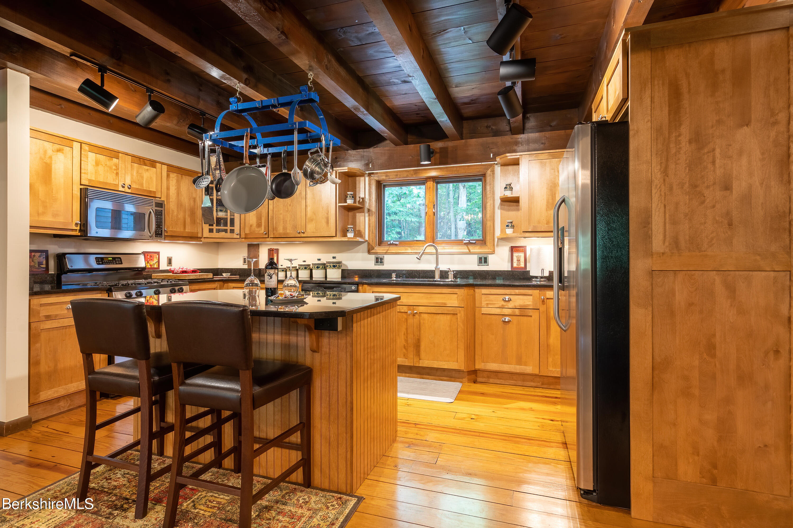 161 Capt Whitney Road Becket, MA 01223 - Photo 13 of 29 a kitchen with stainless steel appliances granite countertop a table chairs and a wooden floor