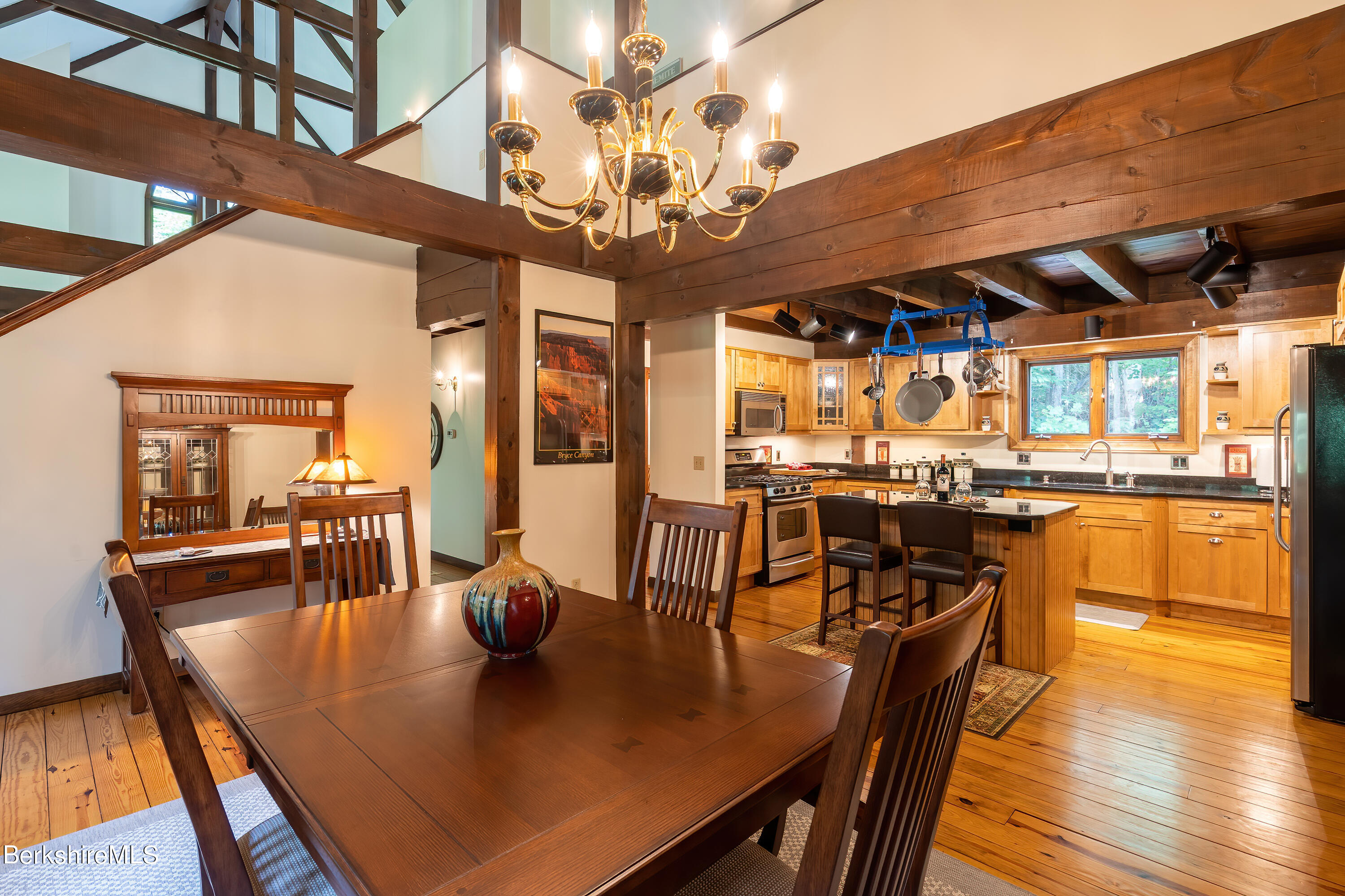 161 Capt Whitney Road Becket, MA 01223 - Photo 10 of 29 a dining room with wooden floor a chandelier a wooden table and chairs