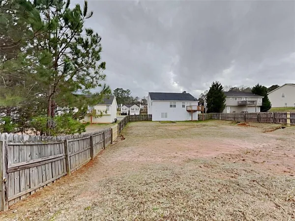 a view of a house with backyard and trees