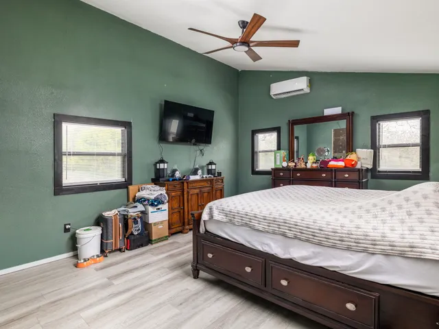 a bed room with a bed window and a flat screen tv