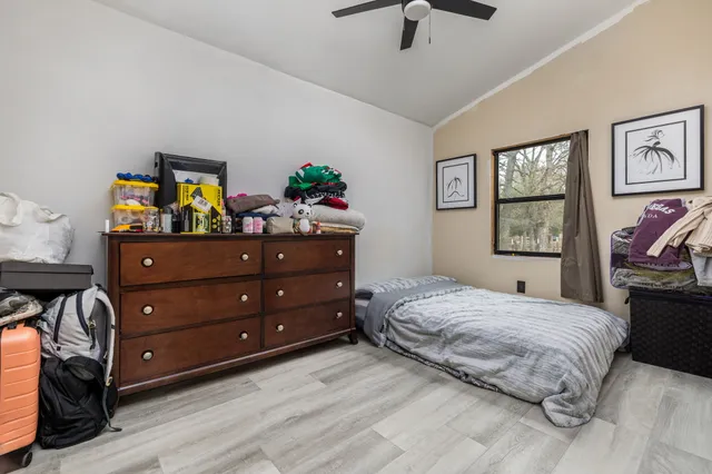 a bedroom with a bed and wooden floor