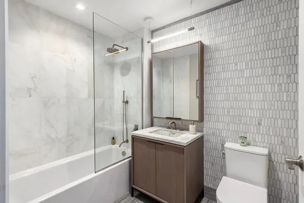 a bathroom with a granite countertop sink toilet and shower