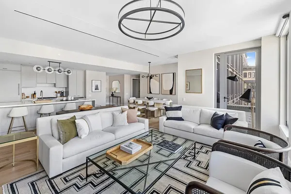 a living room with furniture a large window and a chandelier