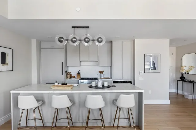 a kitchen with a dining table chairs cabinets and wooden floor