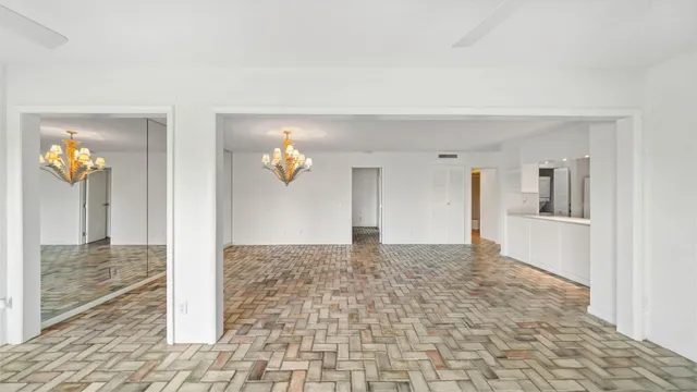 a view of a hallway with wooden floor and a living room