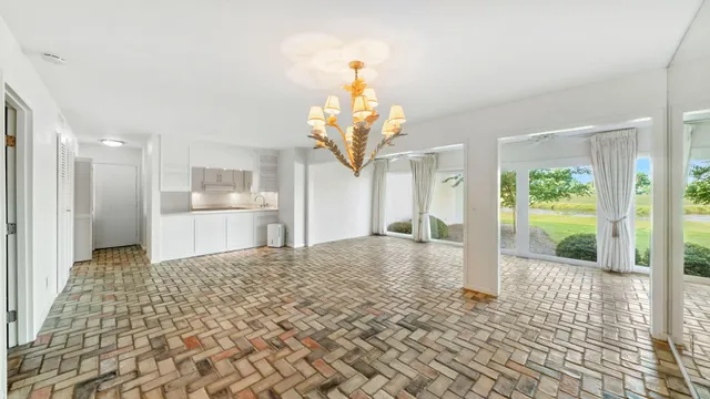 a view of a big room with wooden floor and a chandelier