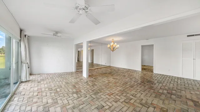 a view of a big room with a chandelier fan and closet area