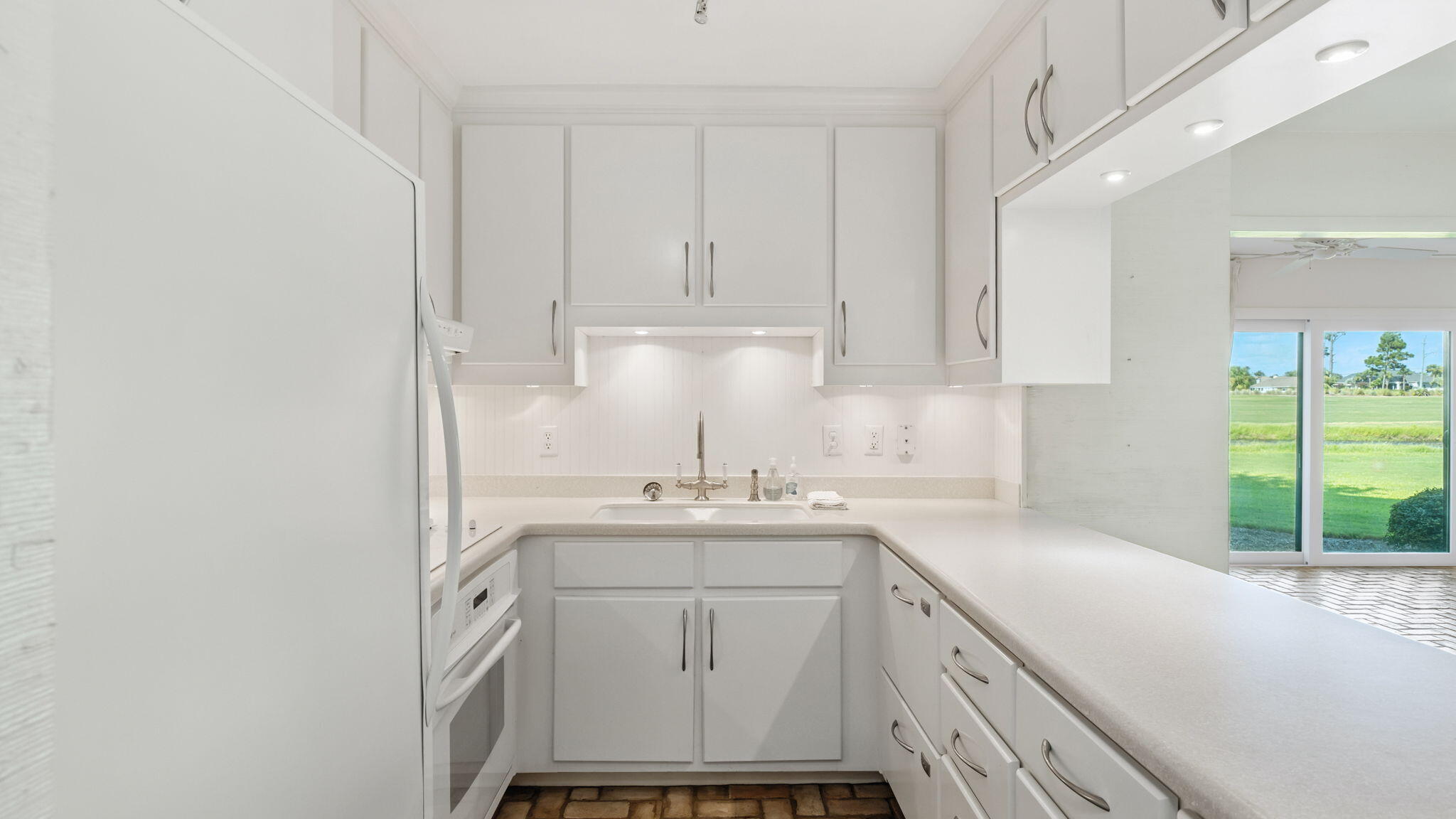 4725 Bay Point Road, Unit 166 Panama City Beach, FL 32408 - Photo 17 of 24 a kitchen with a sink cabinets and window
