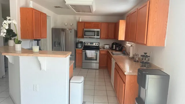 a kitchen with stainless steel appliances granite countertop a refrigerator a stove top oven a sink and dishwasher