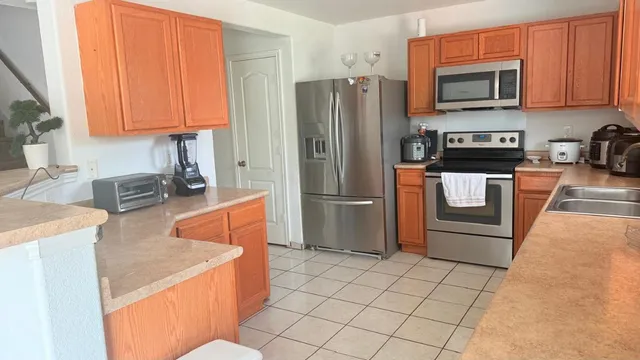 a kitchen with stainless steel appliances granite countertop a refrigerator stove and sink