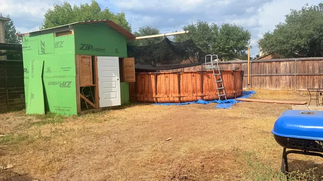 a view of backyard with tub and trees in the background
