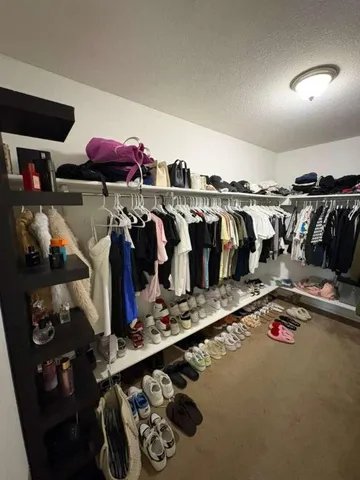 a view of walk in closet with clothes and shoes