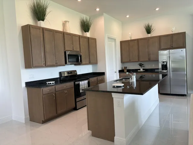 a kitchen with stainless steel appliances granite countertop a sink a stove and a refrigerator