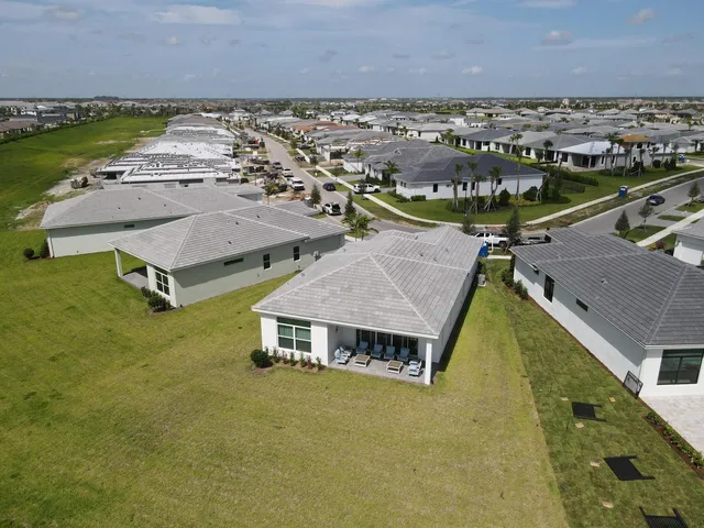 an aerial view of a residential houses with outdoor space and swimming pool