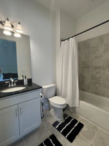 a bathroom with a sink a toilet a mirror and shower