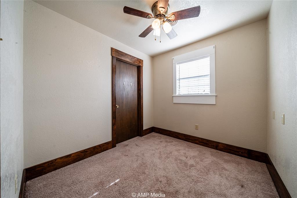 506 East Beauregard Street Rotan, TX 79546 - Photo 14 of 25 an empty room with windows and fan