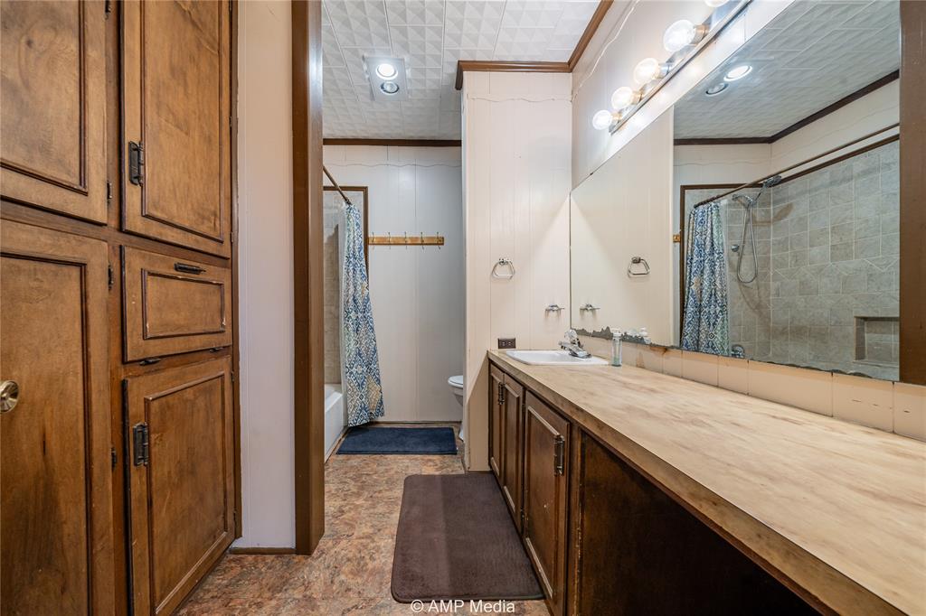 506 East Beauregard Street Rotan, TX 79546 - Photo 15 of 25 a bathroom with a granite countertop sink a mirror and a shower