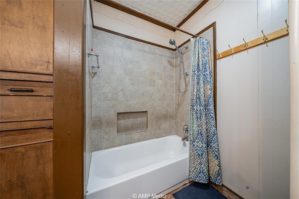 506 East Beauregard Street Rotan, TX 79546 - Photo 16 of 25 a bathroom with a bathtub and a shower