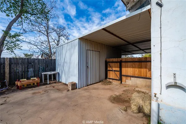 a view of backyard with small cabin and furniture