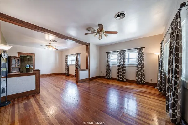 a view of an empty room with window and wooden floor