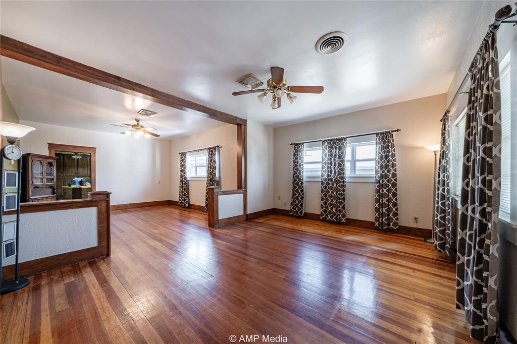 506 East Beauregard Street Rotan, TX 79546 - Photo 5 of 25 a view of an empty room with window and wooden floor