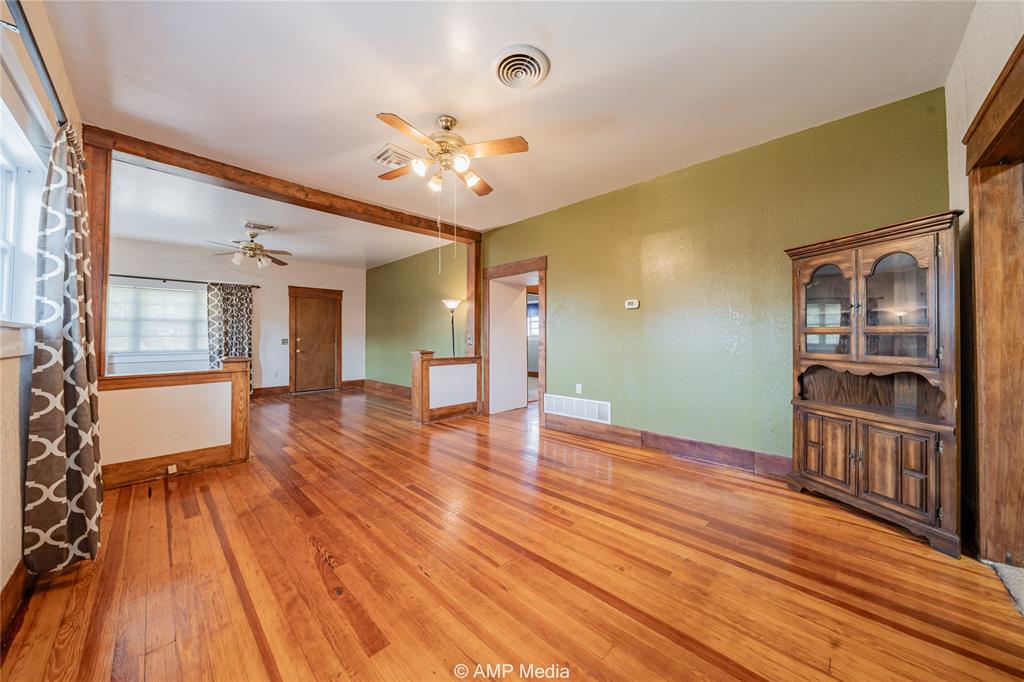 506 East Beauregard Street Rotan, TX 79546 - Photo 6 of 25 wooden floor in an empty room with a window