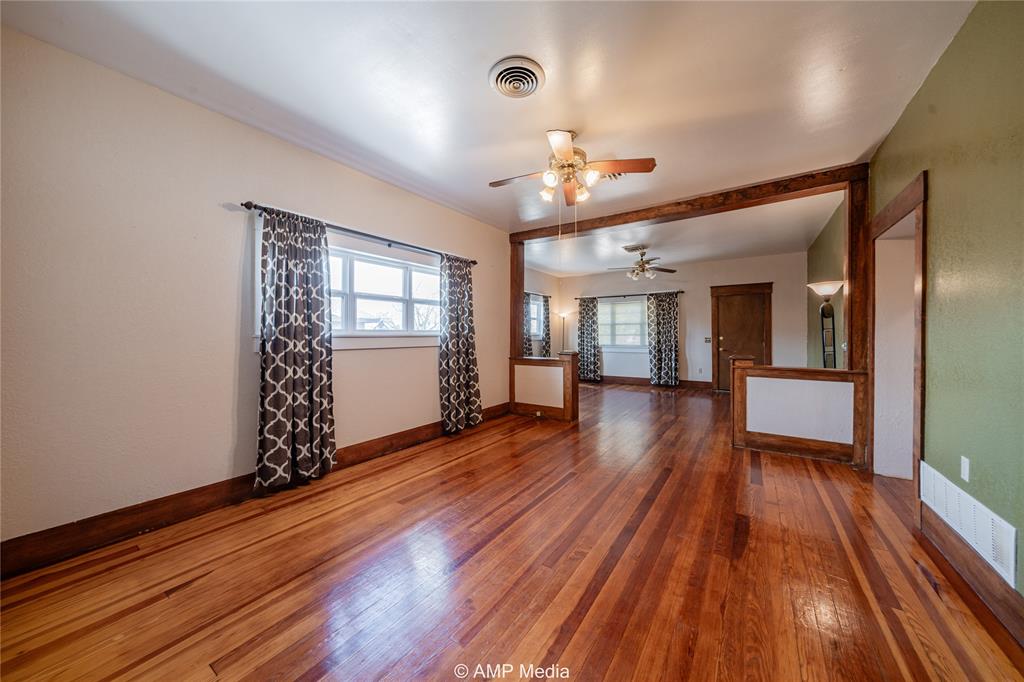 506 East Beauregard Street Rotan, TX 79546 - Photo 7 of 25 wooden floor in an empty room with a window