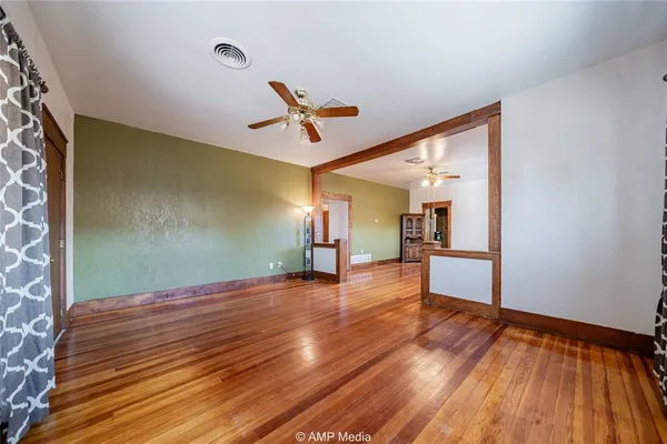 a view of a room with wooden floor and ceiling fan