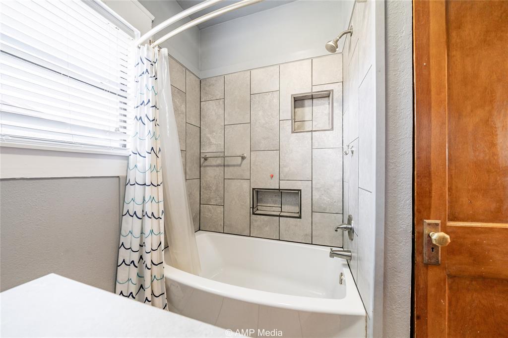 506 East Beauregard Street Rotan, TX 79546 - Photo 10 of 25 a bathroom with a bathtub and a shower