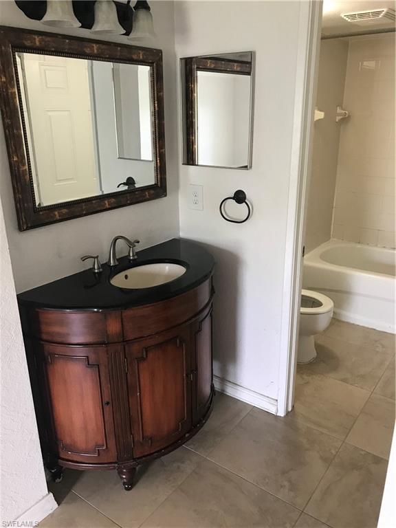 8245 Ibis Club Drive, Unit 409 Naples, FL 34104 - Photo 12 of 18 a bathroom with a sink a toilet and shower