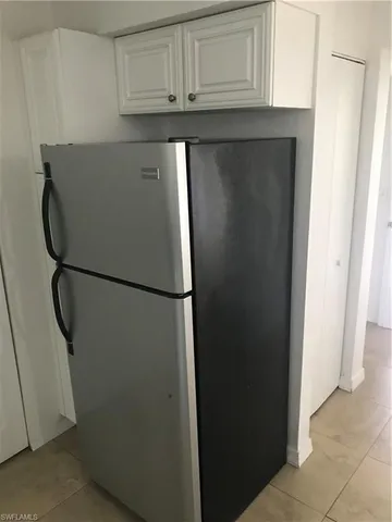 a view of cabinets and refrigerator
