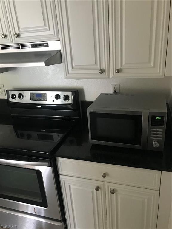 8245 Ibis Club Drive, Unit 409 Naples, FL 34104 - Photo 17 of 18 a stove top oven sitting inside of a kitchen
