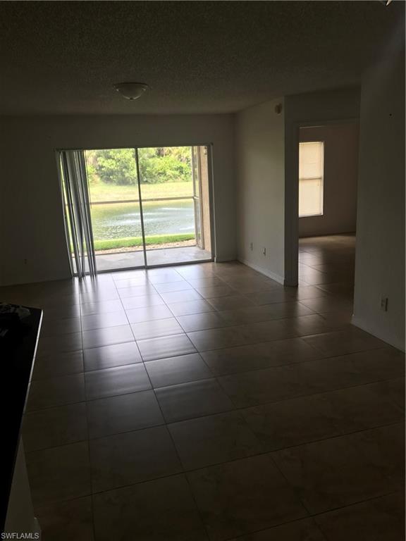8245 Ibis Club Drive, Unit 409 Naples, FL 34104 - Photo 5 of 18 a view of empty room with wooden floor and fan