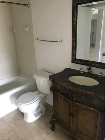 a bathroom with a granite countertop toilet sink and mirror