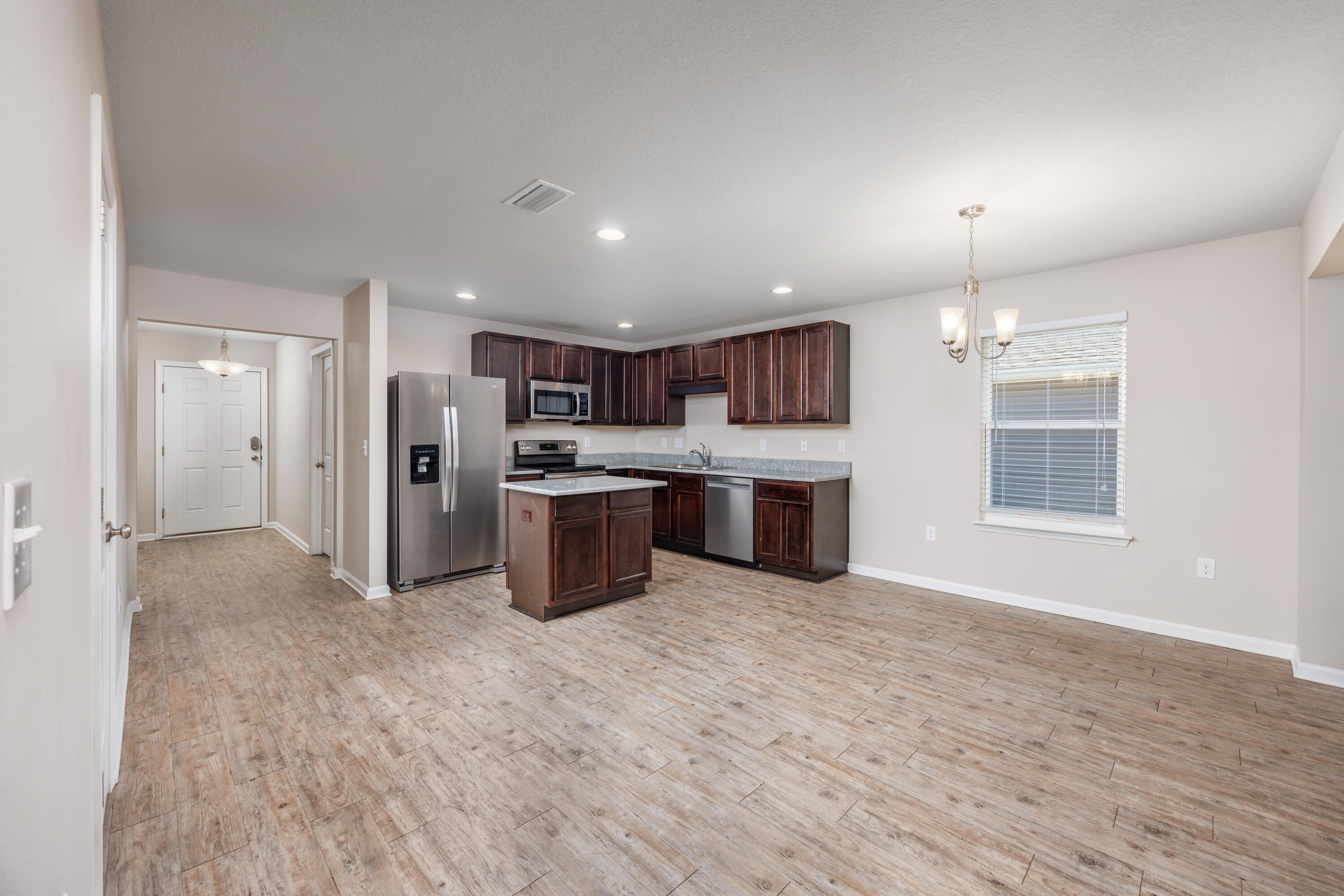617 Fanny Ann Way Freeport, FL 32439 - Photo 5 of 21 a open kitchen with stainless steel appliances granite countertop a refrigerator oven a sink dishwasher and white cabinets with wooden floor