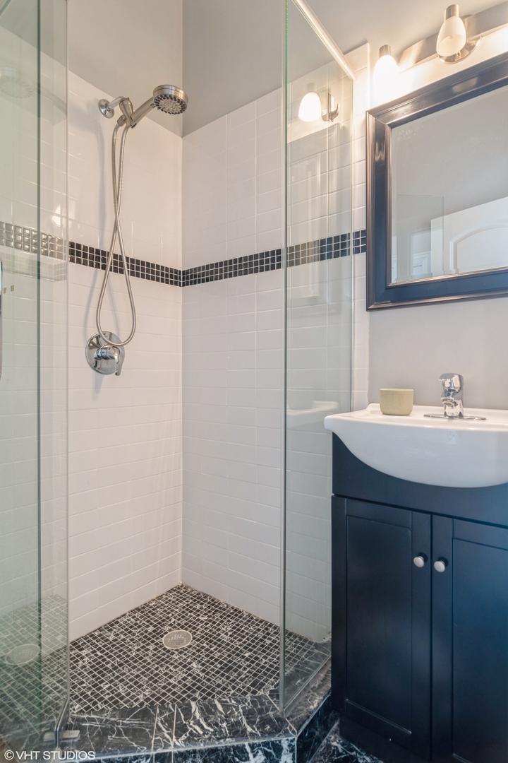 2013 West Rice Street, Unit 3 Chicago, IL 60622 - Photo 9 of 13 a bathroom with a sink a mirror and shower
