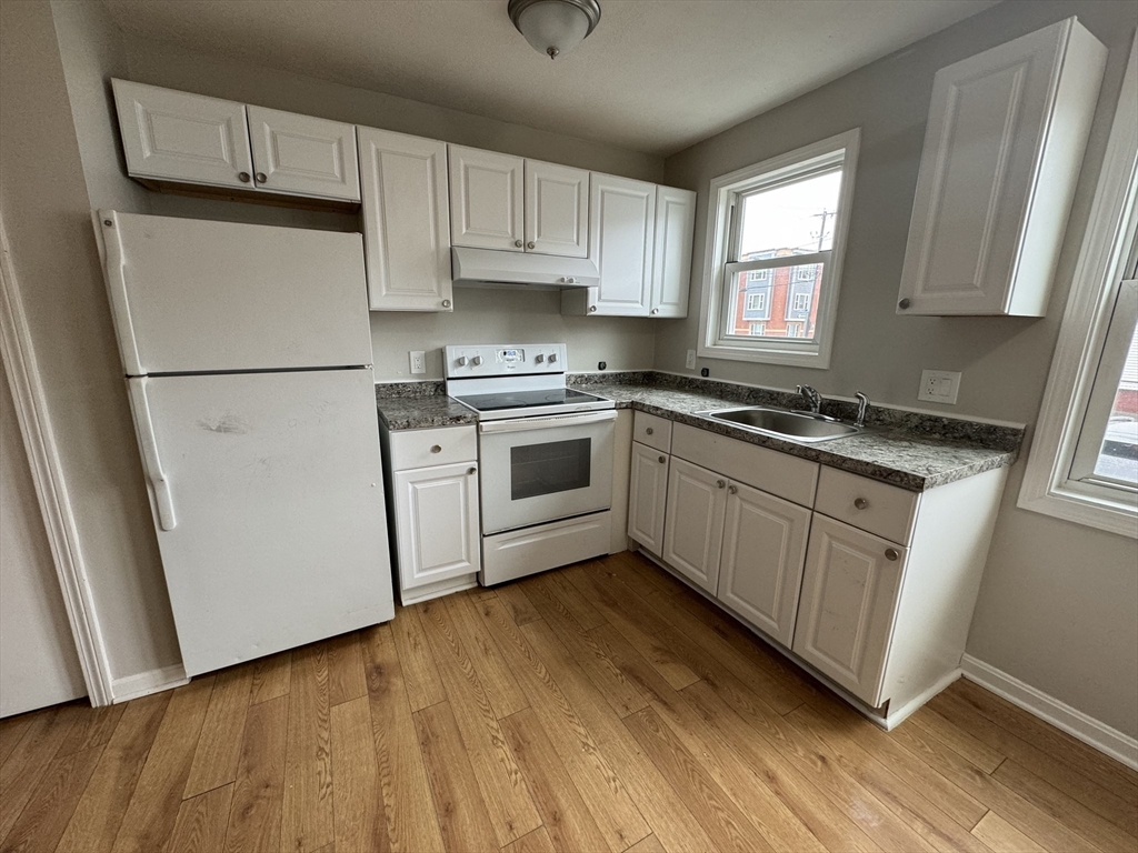 a kitchen with white cabinets sink and white appliances