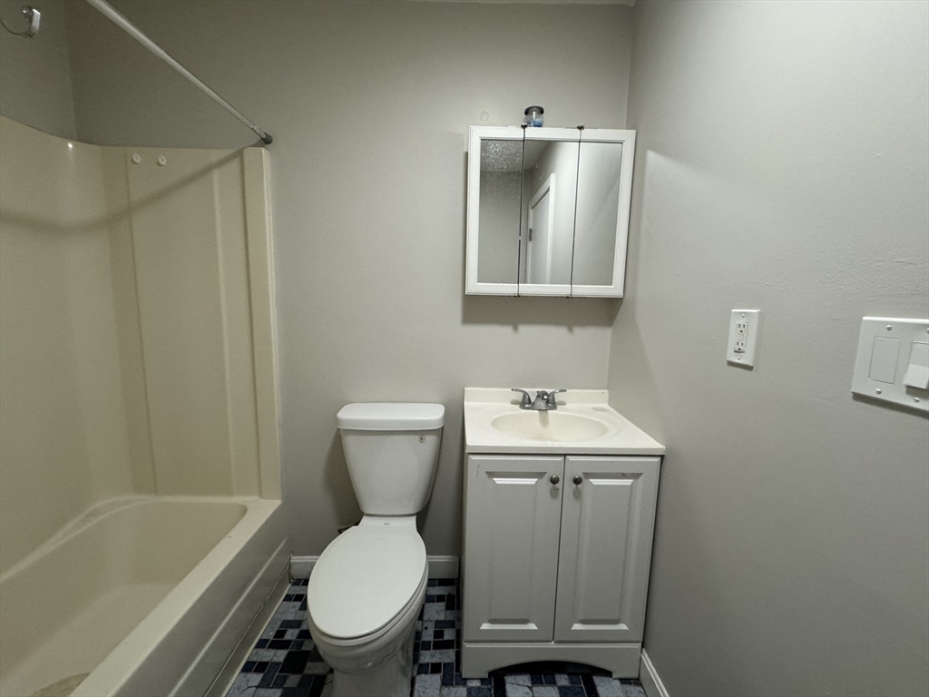 138 Franklin Street, Unit 3 Lynn, MA 01902 - Photo 11 of 11 a bathroom with a toilet sink and mirror