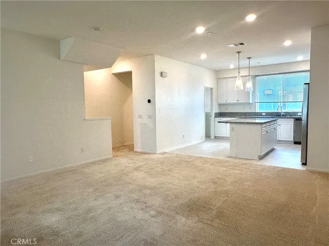 a view of a kitchen with a sink and refrigerator