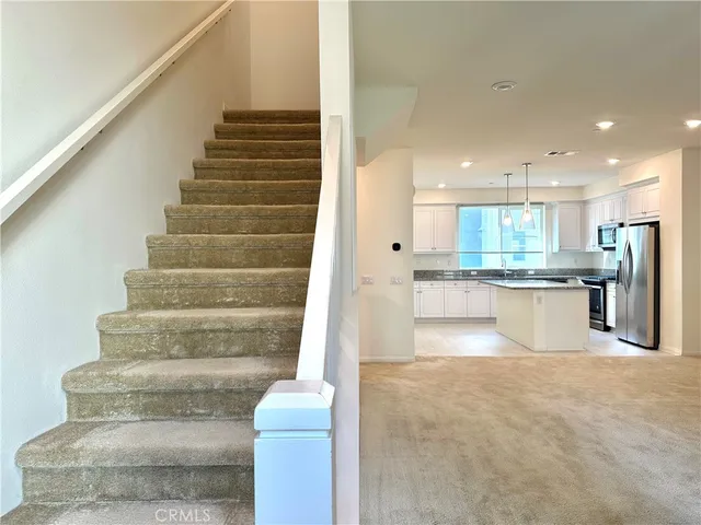 a view of kitchen with white cabinets and refrigerator