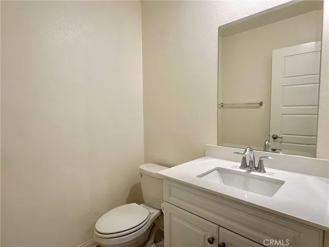 a bathroom with a granite countertop toilet a sink and mirror