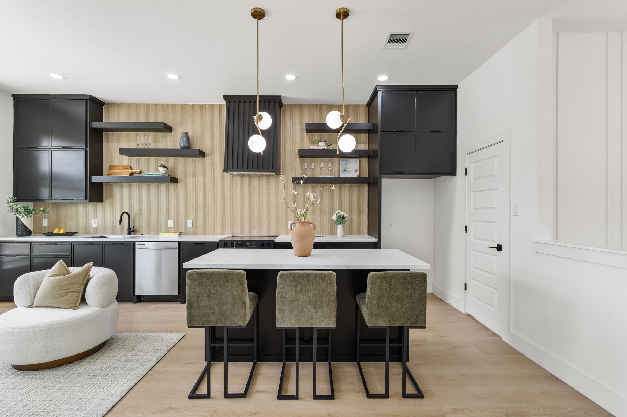 7321 Laura Koppe Road Houston, TX 77028 - Photo 5 of 41 Sleek modern kitchen featuring a large island with stylish pendant lighting, open shelving, and elegant black cabinetry for a chic and functional space.