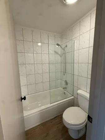 a white toilet and tub sitting next to a bathroom sink