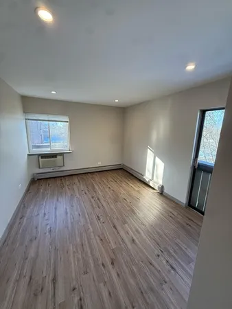a view of empty room with wooden floor